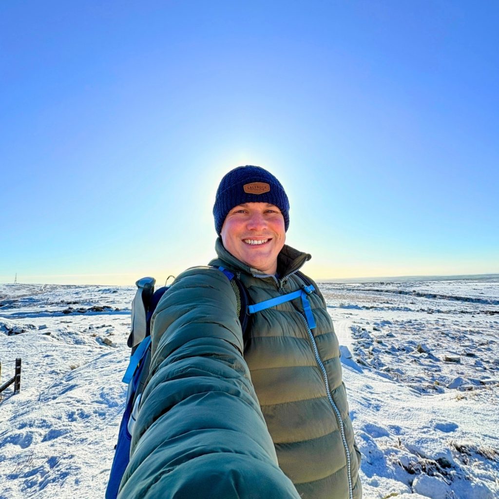 Walking on Bodmin Moor in winter, snowy hiking landscape with backpacker exploring Cornwall