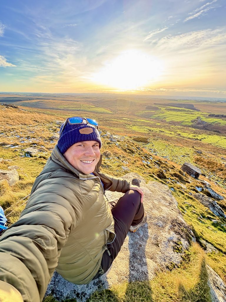 Hiker on Brown Willy Bodmin Moor near Jamaica Inn Cornwall showing landscape of Smugglers Way walking route and remote moorland stay experience